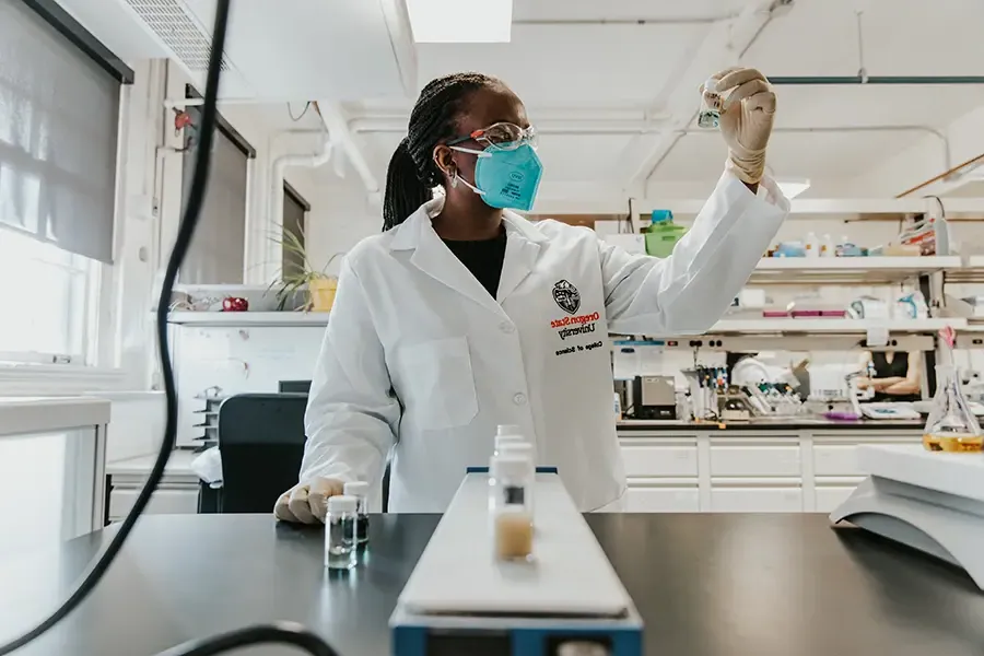 穿着实验室大褂的科学家拿着小瓶